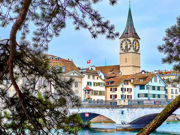 stock image ZURICH, SWITZERLAND - APRIL 3, 2022: Zurich's iconic skyline boasts the Grossmunster and Fraumunster churches, set against the backdrop of the picturesque Limmat River panorama, on April 3 in Zurich, Switzerland