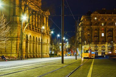 Budapeşte, Macaristan 'daki güzel, aydınlık binalar arasında Lajos Kossuth meydanındaki sarı tramvay yolculukları