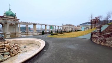 Süslü Buda Şatosu Çarşısı Panoraması Triton Çeşmesi ile, Castle Hill yamacının sütunları ve ağaç bitkileriyle dolu, Budapeşte, Macaristan