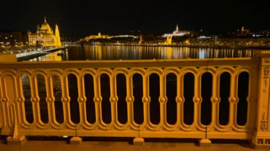 Margaret Köprüsü 'nü Gotik Parlamento binası, Buda Şatosu ve Macaristan' ın Budapeşte, Tuna Nehri 'nin karanlık suları önünde aydınlattı.