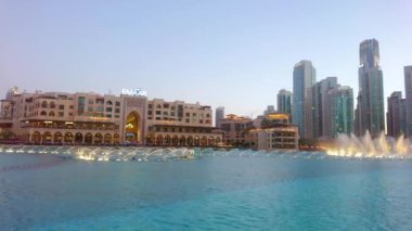 DUBAI, BAE - 3 Mart 2020 'de Dubai' deki Burj Halife Gölü 'nün mavi saatinde altın danseden Dubai Çeşmesi' nin yavaş manzarası