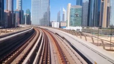 DUBAI, BAE - 3 Mart 2020: Hızlı ve modern Dubai Metro 'nun tadını çıkarın, Red Line, 3 Mart' ta Dubai 'de ünlü gökdelenleri, alışveriş merkezleri ve iş merkezleriyle birlikte şehir merkezinden geçiyor.