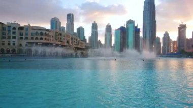 DUBAI, BAE - 4 Mart 2020: Dubai Çeşmesi 4 Mart 'ta Dubai' de renkli pembe, sarı ve mor bulutlu parlak ışık altında harika görünüyor.