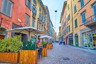 BERGAMO, İtalya - 7 Nisan 2022: Citta Bassa, Bergamo, İtalya 'da Via Sant' Alessandro 'daki dükkanlar ve açık hava yemekleri