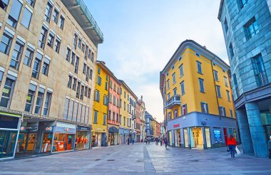 BERGAMO, İtalya - 7 Nisan 2022: Via XX Settembre, Bergamo, İtalya 'da popüler turist dükkanları ve marka butikleri olan renkli evler hattı