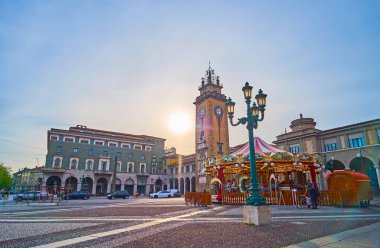 Arka planda klasik sokak lambası, atlıkarınca ve anıt kulesi, Bergamo, İtalya 'daki Piazza Vittorio Veneto üzerinde puslu günbatımı