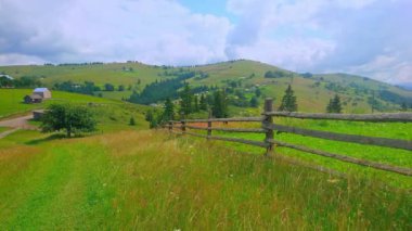 Yeşil çayır boyunca uzanan dar köy yolu ve ahşap çitler, Verkhovyna, Karpatlar, Ukrayna