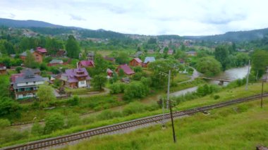 Prut Nehri boyunca bir demiryolu ve arka planda Vorokhta evleri, Karpatlar, Ukrayna