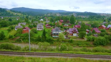 Vorokhta manzaralı yeşil vadisinin panoraması yemyeşil yeşillikler, evler, tarım arazileri, Prut Nehri ve demiryolu, Karpatlar, Ukrayna