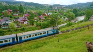 Panorama of Vorokhta landscape with train, riding along the Prut River bank, Carpathians, Ukraine