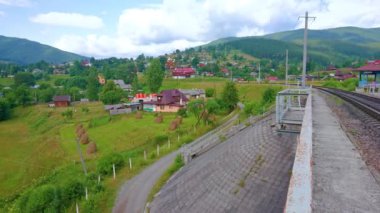 Karpat Dağları 'ndaki yeşil vadinin panoraması Vorokhta evleri ve bahçeleri, kıvrımlı Prut Nehri ve arka plandaki dağlar, Ukrayna