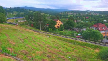 Ukrzaliznytsya 'nın parlak mavi treni Vorokhta, Karpatlar ve Ukrayna' nın evleri boyunca ilerliyor.