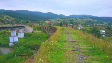 Yeşil çimlerle kaplı demiryolu köprü viyadük kalıntıları ve Karpatlar, Vorokhta, Ukrayna 'nın dağ manzarası gözlemleniyor.
