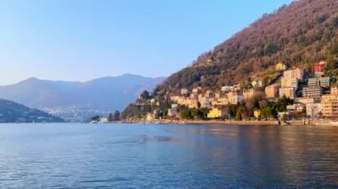 Como Gölü feribot gezisinin zamanı. Arka plandaki sisli Alpler ve akşam güneşinde Monte Boletto yamacı manzaralı. Como, İtalya