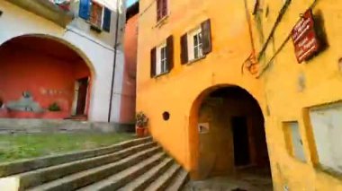 Ortaçağ Castello 'su, dağlık yamaçta dar sokaklar labirenti, eski püskü evler ve manzaralı Alpler ve Lugano Gölü, Valsolda, Lombardy, İtalya