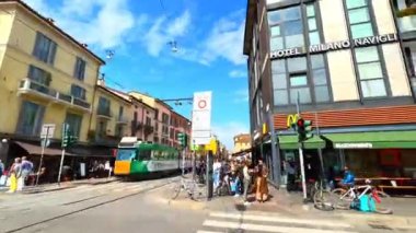 Tarihi Corso di Porta Ticinese 'den geçerek tarihi Corso di Porta Ticinese' nin tadını çıkarın. Porta Ticinese Ortaçağ kapısı. Tarihi evler, şehir manzarası ve antik San Lorenzo Kolonisi, Milan, İtalya.