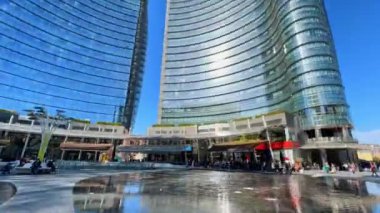 MILAN, ITALY - 9 Nisan 2022: Gae Aulenti Meydanı 'nın çevresindeki, Porta Nuova Garibaldi İş Bölgesi' nin modern cam binaları ve göletli çeşme 9 Nisan 'da Milano' da