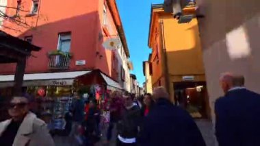 Via Vittorio Emanuele caddesi ve Piazza Flaminia 'nın aşağısında, tarihi evler, palmiye ağaçları ve Garda Gölü, Sirmione, İtalya' ya uzanan eski bir kasabada zaman yürüyüşü.