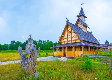 The wooden sculpture with hands, holding a church at the Orthodox temple on the grounds of Kyiv Rus Park, Ukraine clipart