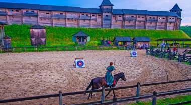 KOPACHIV, UKRAINE - JULY 6, 2021: The partisipant of the horseback archery tournament on arena  in front of the Detinets Citadel of Kyiv Rus Park, Ukraine clipart