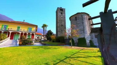 San Quirico Kilisesi 'nin yeşil bahçesinin panoraması yeşil çimenler ve güzel bir pergola ile Maggiore Gölü, Locarno, İsviçre
