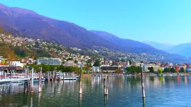 Maggiore Gölü kıyısı demirli tekneler, Muralto evleri ve arka planda puslu Alpler, Locarno, İsviçre