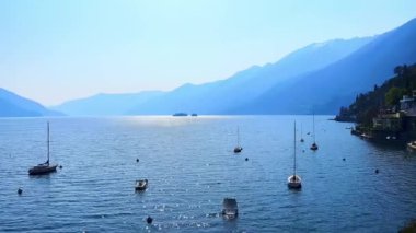 Maggiore Gölü Panoraması 'nda demirli yatlar ve su yüzeyinde parlak güneş yolu, Ascona, İsviçre