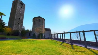 Yeşil çimenli San Quirico Kilisesi 'nin yeşil bahçesi ve arka planda tarihi bir villa ve Maggiore Gölü, Locarno, Ticino, İsviçre