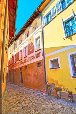 The narrow Via Maistra street with beautiful house, covered with sgraffito in old town of Carona, Ticino, Switzerland clipart