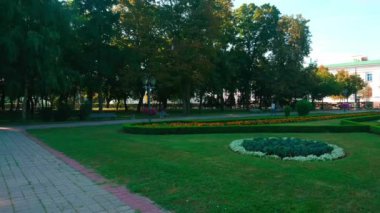 Arkasında güzel çiçek yatakları ve Poltava Savaş Anıtı (Zafer Anıtı) bulunan yemyeşil Hull Park 'ın (Corpus Garden) panoraması, Poltava, Ukrayna