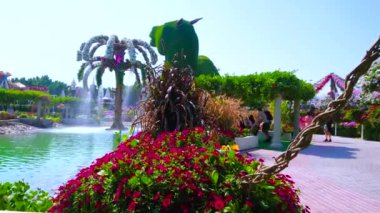 DUBAI, BAE - 5 Mart 2020: 5 Mart 'ta Dubai' de Mucize Bahçesi 'nin palmiye ağacı şeklindeki fıskiyesi, dev çiçek desenleri ve parlak çiçekleri bulunan pitoresk göleti