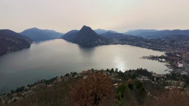 Ceresio Gölü, Monte San Salvatore ve Lugano, Ticino, İsviçre 'deki Monte Bre zirvesinden gün batımının tadını çıkarın.