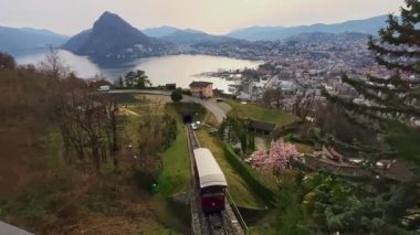 Monte Bre funicular 'ın yavaş giden arabası gün batımına karşı Ceresio Gölü ve Monte San Salvatore ufukta, Lugano, Ticino, İsviçre