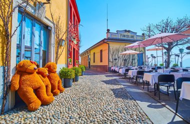 Via al Castello on San Vigilio Hill with vintage houses, outdoor dining and the station of Bergamo - San Vigilio funicular in background, Bergamo, Lombardy, Italy clipart