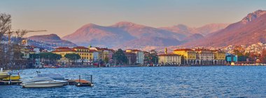 Lugano 'da sakin bir akşam, Ceresio göl manzaralı tarihi konaklar ve parlak günbatımı ışığında dağlar, Ticino, İsviçre