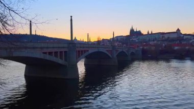 Vltava Nehri 'nden eski Prag' ın alacakaranlık silueti Petrin Tepesi, Petrin Gözcü Kulesi, Prag Şatosu 'nun St Vitus Katedrali ve Çek Cumhuriyeti' nin Mala Strana kentinin konutları ile.