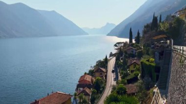 Iconic Valsolda manzarası Albogasio 'nun yeşil bahçeleri, Oria Gölü ve Lugano Gölü' nün eski çatıları (Ceresio), puslu Alpler, Lombardiya, İtalya