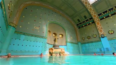 BUDAPEST, HUNGARY - 24 Şubat 2022: Gellert Spa 'nın duvarlarında mozaik desenler ve erkek çocuklu heykel havuzu, kaplumbağalar, Budapeşte, Macaristan