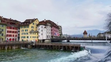 Reuss-Nadelwehr (İğne Barajı) ile hızlı akan Reuss Nehri, setin üzerindeki renkli vintage evler, Reusssteg köprüsü ve arka planda ortaçağ Su Kulesi, Lucerne, İsviçre