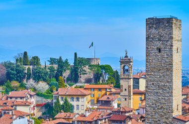 Yukarı şehrin çatıları olan Bergamo Alta, selvi dolu yemyeşil park, Rocca di Bergamo kalesi, uzun taş Torre del Gombito, İtalya