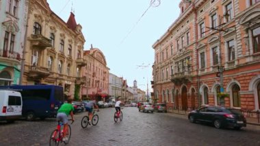 CHERNIVTSI, UKRAINE - 16 Temmuz 2021: Ana Cadde 'deki geniş yol ve akşam trafiği (Holovna Caddesi), heykeltraş tarihi yapılar boyunca klasik troleybüsler, 16 Temmuz' da Chernivtsi 'de