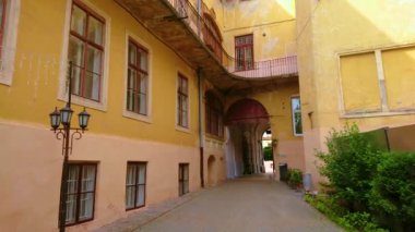 Eski püskü avlu, Ukrayna 'nın Chernivtsi kentindeki Kobylyanska sokağına bağlanan geçitli uzun sarı binalarla çevrilidir.