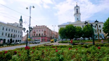 CHERNIVTSI, UKRAINE - 16 Temmuz 2021: Tarihi belediye binasının önündeki Central Square 'de çiçek açan güllerle birlikte manzaralı çiçek tarhı, 16 Temmuz' da Chernivtsi