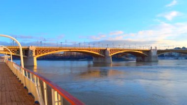 Tuna Nehri 'nin karşısındaki Margaret Köprüsü' nün panoraması. Macaristan 'ın Budapeşte kentinde nehrin arkasında altın gün doğumu.
