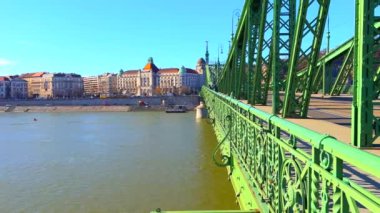 Geniş Tuna Nehri üzerinde parlak yeşil Özgürlük Köprüsü ve Budapeşte, Macaristan 'ın arka planında Buda' nın binaları bulunuyor.