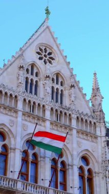 Tarihi Parlamento cephesinin zengin Gotik stil oymaları, çelenkler, heykeller, kavisli ve gül pencereleri, bakır şövalye tepesi ve Macaristan, Budapeşte bayrağı