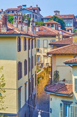 Citta Alta 'nın klasik yoğun mimarisi, kasaba evleri arasında uzanan dar Via Tassis manzaralı, Bergamo, İtalya