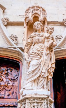 The stone statue of Virgin Mary with child at the entrance to Basilique Saint Pierre, Avignon, France clipart