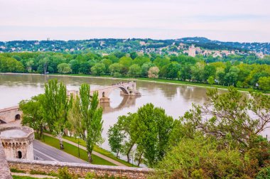 Ünlü Pont Saint-Benezet (Pont d 'Avignon), Fransa' nın Avignon şehrinin duvarından görülebilen Rhone Nehri seti üzerindeki yeşil ağaçlar arasındadır.