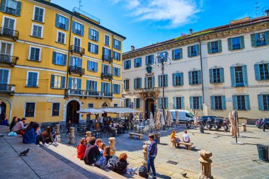 MILAN, ITALY - 08 Nisan 2022: Öğrenciler 8 Nisan 'da İtalya' nın Milano kentinde, Piazza Sant 'Alessandro' daki merdivenlerde oturup öğle yemeği yiyorlar